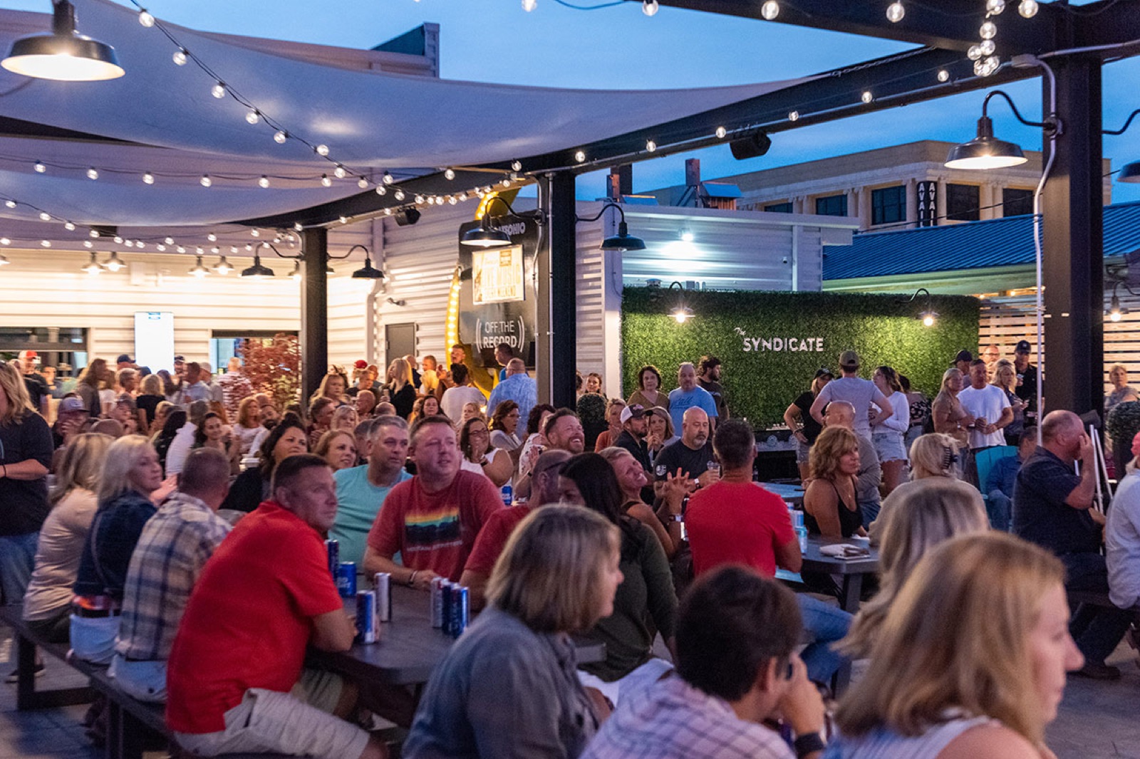 A full crowd enjoying live music in The Backyard at dusk